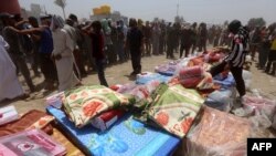 Iraqi families, who fled the city of Ramadi after it was seized by Islamic State militants, queue to receive aid at a camp for the internally displaced in Amriyat al-Fallujah, 30 kilometers south of Fallujah, May 22, 2015.