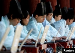 FILE - South Koreans in traditional scholar costumes use laptops at the digital version of a state examination, which were carried out during the Chosun Dynasty, at Sungkyunkwan University in Seoul May 14, 2006.