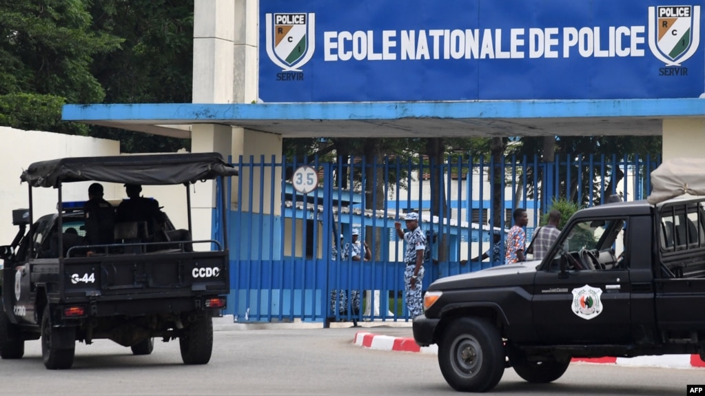 A picture taken on July 20, 2017 shows two vehicles of the Ivorian police's special forces (CCDO) outside the entrance to the National Police Academy in the Cocody district in Abidjan, where gunshots were reportedly fired on July 19. 