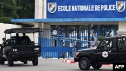 A picture taken on July 20, 2017 shows two vehicles of the Ivorian police's special forces (CCDO) outside the entrance to the National Police Academy in the Cocody district in Abidjan, where gunshots were reportedly fired on July 19. 