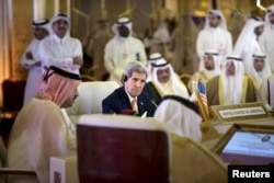 U.S. Secretary of State John Kerry (C) listens while Oman's Foreign Minister Yusuf bin Alawi (L) speaks during a meeting of foreign ministers of the Gulf Cooperation Council (GCC) in Doha Aug. 3, 2015.