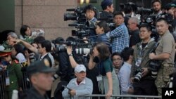 In this Wednesday, Feb. 27, 2019 photo, journalists gather outside Metropole hotel where U.S President Donald Trump and North Korean leader Kim Jong Un are to have their meeting in Hanoi, Vietnam. (AP Photo/Vincent Yu)