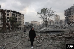 Warga Palestina berjalan melewati puing-puing di tengah kehancuran akibat serangan udara Israel di lingkungan al-Rimal Kota Gaza pada awal 10 Oktober 2023. (Foto: AFP)