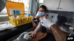 Un travailleur social pulvérise du désinfectant sur la blessure d'un enfant sans-abri à l'intérieur de l'une des unités mobiles gérées par les autorités égyptiennes et utilisé dans le cadre du programme social "Enfants sans domicile", le 22 juin 2020.