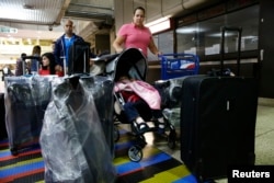 FILE - Natalie Pereira, center, queues to go through migration before her move to the U.S. with her family, after winning a green card lottery, at the Maiquetia airport in Caracas, Apr. 8, 2014.