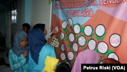 Sejumlah anak menuliskan harapan mereka melalui Pohon Harapan sebagai ungkapan kerinduan pada kampung halaman setelah 4 tahun menjadi pengungsi, Jumat, 1 Juli 2016. (VOA/Petrus Riski)