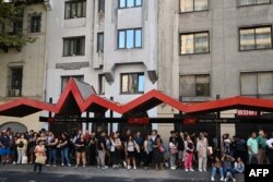 People wait as they attend on a bus stop during a blackout in Santiago, Chile, Feb. 25, 2025.