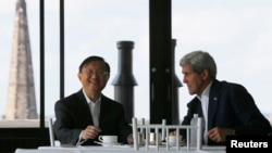 China's State Councillor Yang Jiechi, left, and U.S. Secretary of State John Kerry talk over tea during a day of meetings in Boston, Massachusetts, Oct. 18, 2014. 