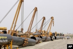 FILE - Sections of gas pipes are seen at the start of construction on a pipeline to transfer natural gas from Iran to Pakistan, in Chabahar, southeastern Iran, near the Pakistani border, March 11, 2013.