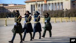 几名戴着口罩的中国武警士兵在北京天安门广场列队行走。（2020年2月4日）