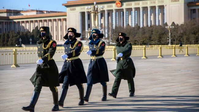 几名戴着口罩的中国武警士兵在北京天安门广场列队行走。（2020年2月4日）