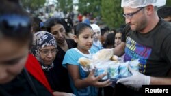 Des migrants syriens font la queue pour obtenir de la nourriture d'une ONG locale sur le côté d'une route près d'Edirne en Turquie, le 17 septembre 2015.