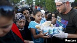 Para migran Suriah antri untuk mendapatkan pembagian makanan dari LSM lokal di kamp mereka di Edirne, Turki (foto: dok). 