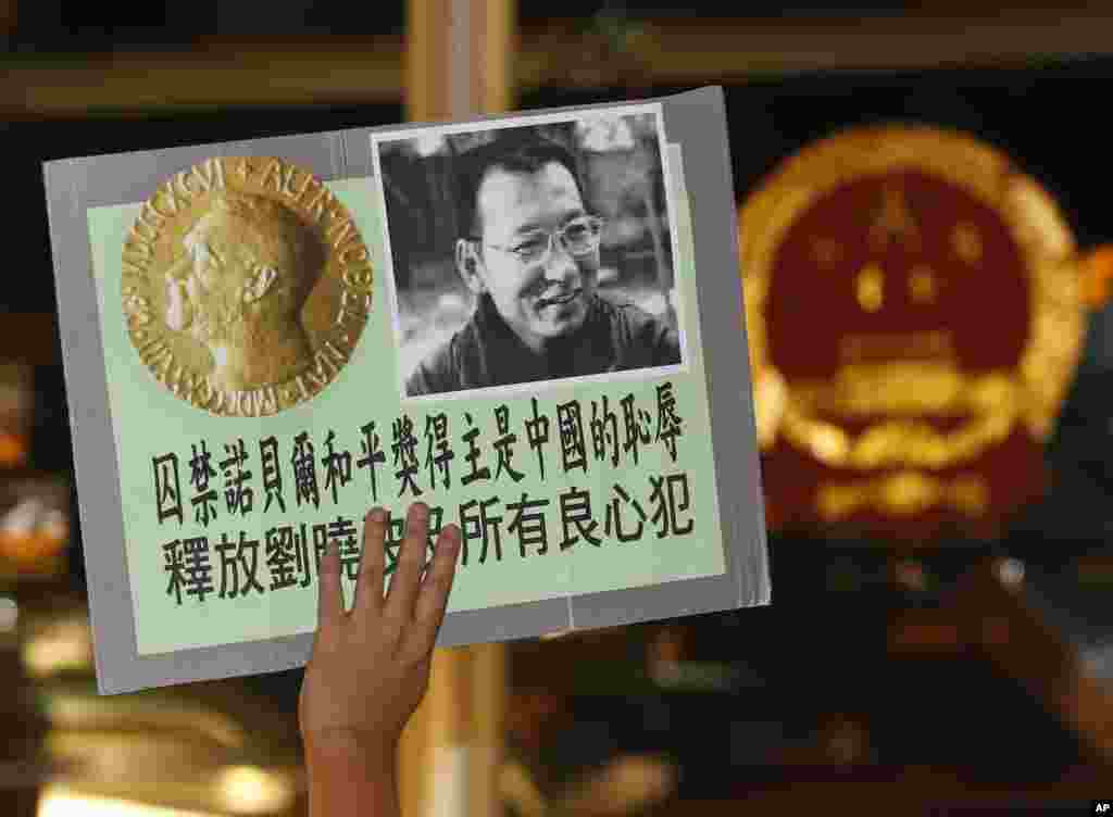 2010年10月8日，正在监牢服刑的《零八宪章》起草人、中国民主运动人士刘晓波获得诺贝尔和平奖的消息传来，香港民主活动人士前往中国驻香港联络办公室大楼前示威，敦促中国政府释放刘晓波，人们举着刘晓波及诺贝尔奖牌的照片。