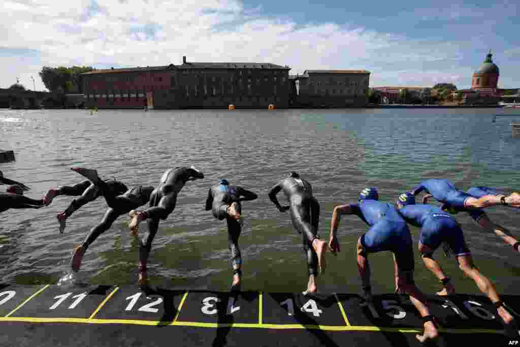 Triathletes dive into the Garonne river as they compete in the men&#39;s Supertri triathlon in Toulouse, south-western France.