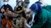 Seorang petugas kesehatan menyuntikkan vaksin Sinovac kepada seorang pria berkostum wayang, saat pemerintah melakukan vaksinasi massal untuk COVID-19, di Jawa Tengah. (Foto: Antara via Reuters)