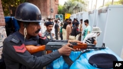 Pakistani cricket fans enter the Gaddafi stadium under tight security to watch Pakistan vs Zimbabwe match in Lahore, Pakistan, May 22, 2015. 