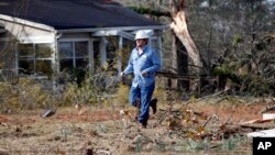 A Central Electric Power Association lineman pulls a new line across the debris littered lawn of a Scott County, Mississippi resident, Nov. 30, 2016, that was damaged by an apparent tornado Tuesday afternoon. With crowd-sourced mapping rescue workers will have the information they need, such as which roads, buildings and bridges have been destroyed. 