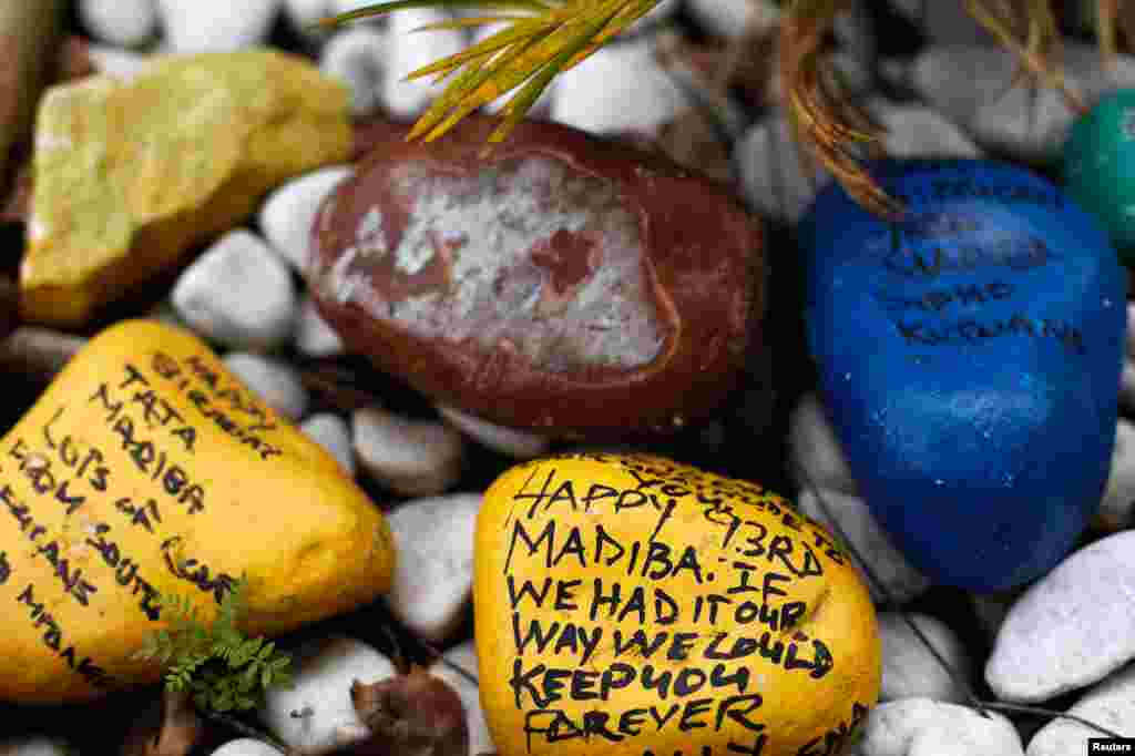 Pedras pintadas com desejos de r&aacute;pidas melhoras para Nelson Mandela deixadas num jardim &agrave; porta de sua casa em Joanesburgo.
