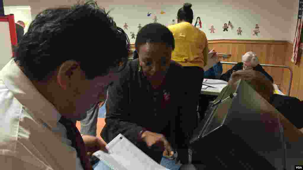 Des électeurs de Mamaroneck, ville américaine située dans le comté Westchester, dans l’Etat de New York, viennent voter à la dernière minute dans les primaires peu avant la fermeture du bureau de vote à 21hrs, le mardi 19 avril 2016 (VOA/Jacques Aristide)