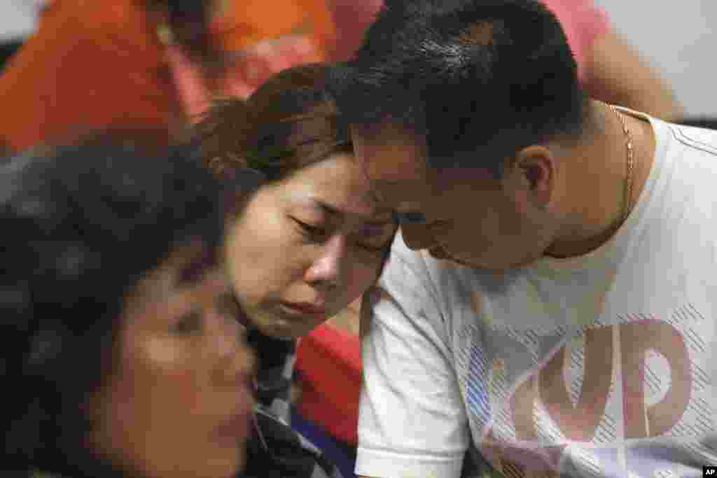 Seorang keluarga penumpang AirAsia QZ8501 menangis sambil menunggu berita terbaru tentang pesawat yang hilang tersebut di pusat krisis yang didirikan oleh otorita lokal di Bandara Internasional Juanda di Surabaya, Jawa Timur, Indonesia, 28 Desember 2014.