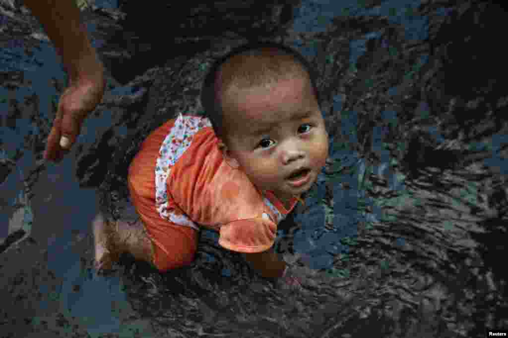 A girl plays in water from a water pavilion during celebrations of the Burma New Year Water Festival in Rangoon.