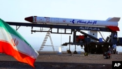 In this undated photo obtained from the Iranian Students News Agency, ISNA, a rocket dubbed, 'Pishgam,' or 'Pioneer' is seen ahead of a space launch at an undisclosed location in Iran.