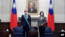 FILE - Taiwanese President Tsai Ing-wen, right poses for a photo after awarding a medal of honor to Alain Richard, the head of the French Senate's Taiwan Friendship Group, at the Presidential Office in Taipei, Taiwan, Oct. 7, 2021.