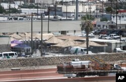 Migrants are seen in a fenced-off area an outdoor encampment where they’re waiting to be processed in El Paso, Texas, June 12, 2019. The Trump administration is facing growing complaints about severe overcrowding, meager food and other hardships.