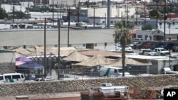 Migrants are seen in a fenced-off area an outdoor encampment where they’re waiting to be processed in El Paso, Texas, June 12, 2019. The Trump administration is facing growing complaints about severe overcrowding, meager food and other hardships.