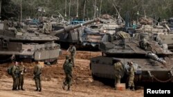 Tentara Israel berdiri di tank dan pengangkut personel lapis baja (APC) dekat perbatasan dengan Gaza, di Israel selatan, 26 Maret 2019.