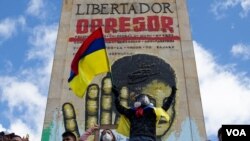 A protester waves a Colombian flag in front of a monument honoring Simon Bolivar in Bogota, Colombia, July 20, 2021. (Megan Janetsky/VOA)