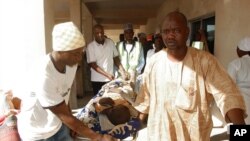 Rescue workers transport a victim of a suicide bomb attack at a refugee for treatment at a hospital in Maiduguri, Nigeria, Feb. 10, 2016.