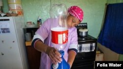 A woman in South Africa purifies drinking water by using a Folia Water paper water filter. Patented in 2016 by US scientist Theresa Dankovich, it works like a high-tech coffee filter and kills most waterborne bacteria and viruses. (Courtesy Folia Water)