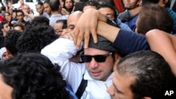 FILE - Ahmed Maher, center, is a leader of the April 6 youth group that had a leading role in the 2011 uprising against former president Hosni Mubarak, Nov. 30, 2013.