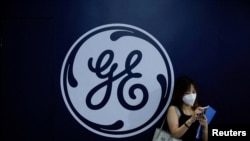 资料照片：在上海召开的世界人工智能大会期间，一位女士站在通用电气(GE)的标识前。(2022年9月1日)