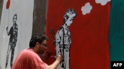 Un artiste yéménite et sa contribution à la campagne contre le recrutement d'enfants soldats par les milices tribales, Sana'a, le 10 avril 2014. 