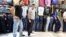 FILE - Young Iranian men pose in a shop selling jeans in Tajrish Bazaar in Tehran.