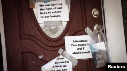 Signs are taped to the front door of a home in the New Dorp Beach area in the Staten Island borough of New York, Sept. 20, 2013.