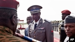 Pemimpin kudeta Burkina Faso Jenderal Gilbert Diendere (tengah) hendak menyambut kedatangan Presiden Niger Mahamadou Issoufou di bandar udara Ouagadougou, Burkina Faso (23/9).