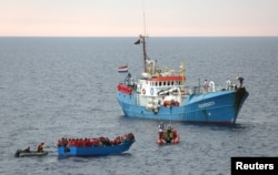 FILE - Migrants on a wooden boat are rescued by crew from the German NGO Jugend Rettet ship Iuventa in the Mediterranean Sea off Libya coast, June 18, 2017.