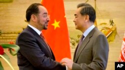 FILE - Afghan Foreign Minister Salahuddin Rabbani, left, and Chinese Foreign Minister Wang Yi, right, shake hands at the end of a joint press conference at the Ministry of Foreign Affairs in Beijing, Jan. 26, 2016.