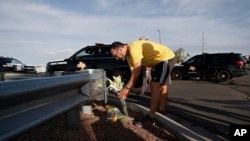 A man leaves flowers near the scene of a mass shooting at a shopping complex Sunday, Aug. 4, 2019, in El Paso, Texas. (AP Photo/John Locher)