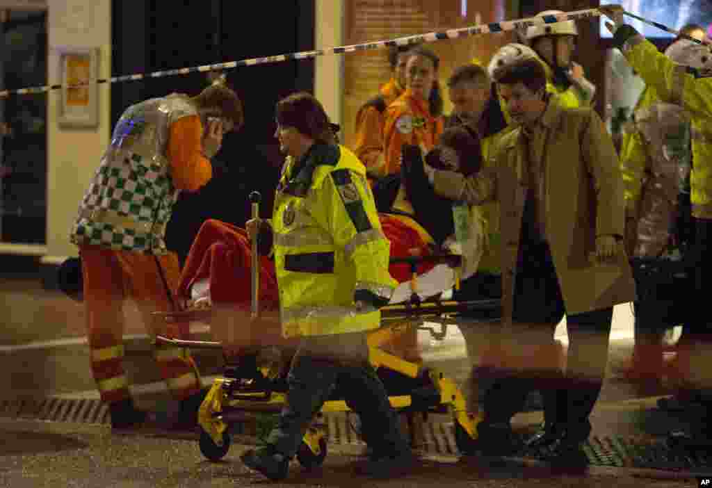 People receive medical attention after part of the ceiling collapsed at the Apollo Theatre, Shaftesbury Avenue, London, Dec. 19, 2013.