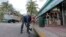  FILE - Miami-Dade mosquito-control inspector Yasser "Jazz" Compagines sprays a chemical mist into a storm drain, Aug. 23, 2016, in Miami Beach, Fla. The spread of the Zika virus has been limited in Florida thanks to aggressive mosquito control.