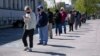 Personas hacen fila frente a un centro profesional recientemente reabierto para citas en persona en Louisville, Kentucky, el 15 de abril de 2021.