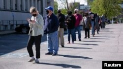 Personas hacen fila frente a un centro profesional recientemente reabierto para citas en persona en Louisville, Kentucky, el 15 de abril de 2021.