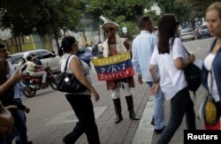 A man holding a Venezuela flag with the words "Freedom, peace, justice" stands on a street in Caracas, Venezuela, July 21, 2017.