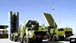 Government employees arrive to work as they walk along an area occupied by protesters outside of the government headquarters building in Hong Kong, Oct. 6, 2014. 