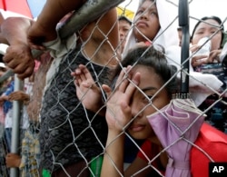 Typhoon survivors queue up at Tacloban city airport hoping to be able to board U.S. and Philippine military transport planes, Nov. 13, 2013, in Tacloban city, Leyte province in central Philippines.